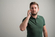 © Cipri Suciu  - Portrait of serious stylish attractive man with thick beard, dressed in casual green t shirt talking on the phone
