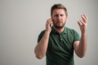 © Cipri Suciu  - Portrait of serious stylish attractive man with thick beard, dressed in casual green t shirt talking on the phone