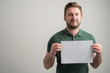 © Cipri Suciu  - Portrait of serious stylish attractive man with thick beard, dressed in casual green t shirt holding white paper
