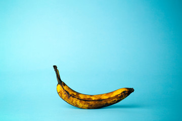 Wall Mural - Ripe banana on a blue background. Ripe tropical fruits, food still life concept