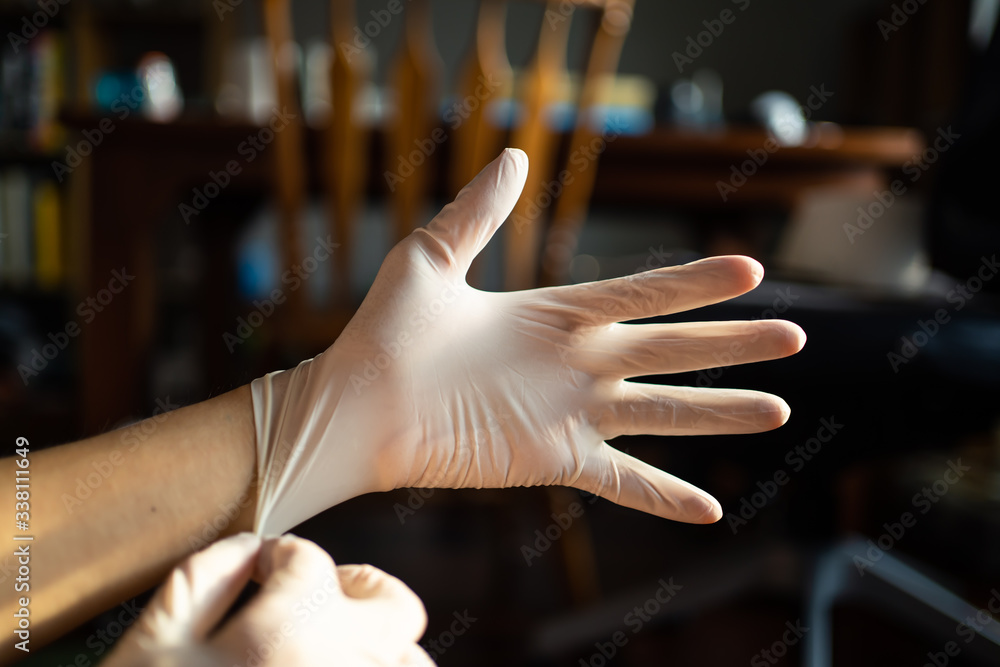 wearing disposable latex gloves to avoid the contact with viruses on the frequently touched surfaces - obrazy, fototapety, plakaty 