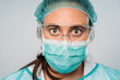 © ManuPadilla - Close up of a Young woman doctor wearing medical mask, glasses, latex gloves and protective clothing against the virus on white background. COVID-19 The coronavirus pandemic.