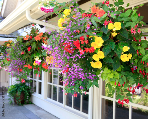 Fotografía Blooming flowers amazing complex baskets hanging pots near small luxury lodge exterior