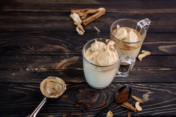 Wall Mural - Delicious and fragrant dalgona coffee in glass cups, cinnamon sticks, dried mushrooms, a spoon of instant coffee, sugar.