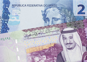 A five Saudi riyal bank note with a blue two Brazilian reais bill.  Shot in macro.