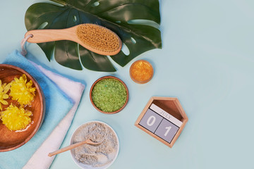 spa massage clay powder, face masks, bath salt, towel, shea butter on blue table background.