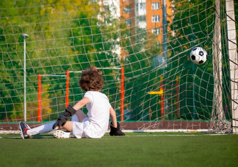 Wall Mural - Summer soccer tournament for young kids. football club. emotions and joy of the game. Young goalie. Kids - soccer champion. Boy goalkeeper in football sportswear on stadium with ball. Sport concept.