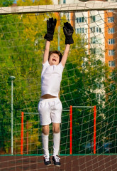 Wall Mural - Summer soccer tournament for young kids. football club. emotions and joy of the game. Young goalie. Kids - soccer champion. Boy goalkeeper in football sportswear on stadium with ball. Sport concept.