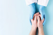 © Olga Zarytska - Doctor's hands in gloves holding man's hands. Medical background with copy space. Care concept.
