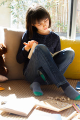 Wall Mural - studious child reading with teddy bear and board games around