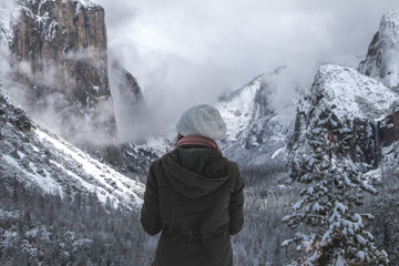 Wall Mural - rear view of hiker standing in snowy yosemite valley