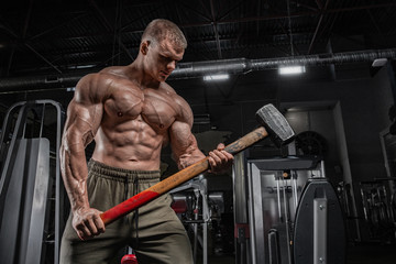 Portrait of handsome sporty man with naked muscular torso doing weight lifting