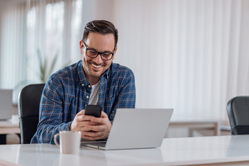 Wall Mural - Businessman sitting at the desk and using smart phone