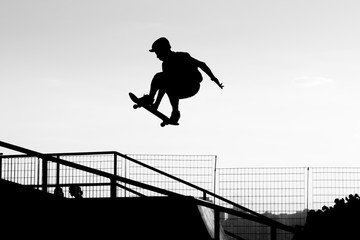 Wall Mural - Silhouette of a skateboarder jumping in a skatepark