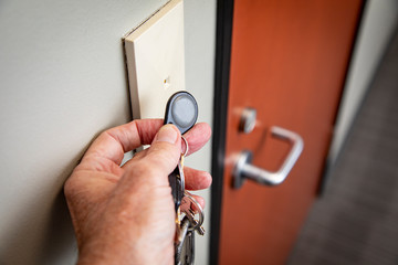 Close up of hand holding key FOB to gain access to an interior office door