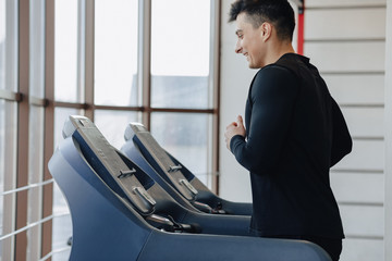 stylish guy in the gym is training on the treadmill. Healthy Lifestyle.