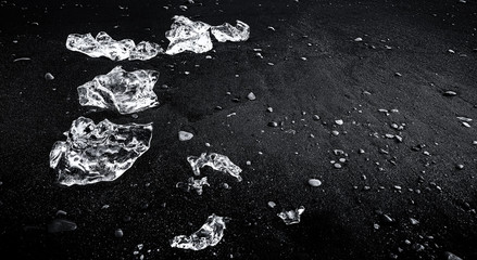 Ice floes and smaller chunks broken off larger icebergs tha thave floated out to the open ocean wash up on a black sand Iceland Beach