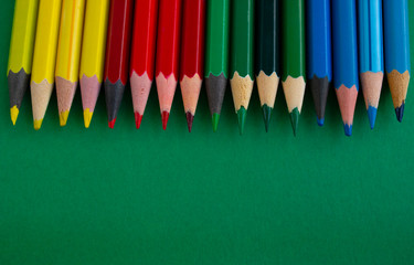 colored pencils isolated on green background