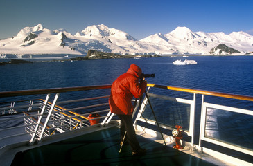 Wall Mural - Photographer on cruise ship Marco Polo with glaciers and icebergs in Paradise Harbor, Antarctica
