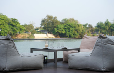 Bean bags seating and low timber for dining set with river background