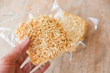 instant noodles in package in hand dry food non perishable storage goods in kitchen home or for donations