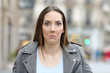© Antonioguillem - Confused young woman looking at camera in the street