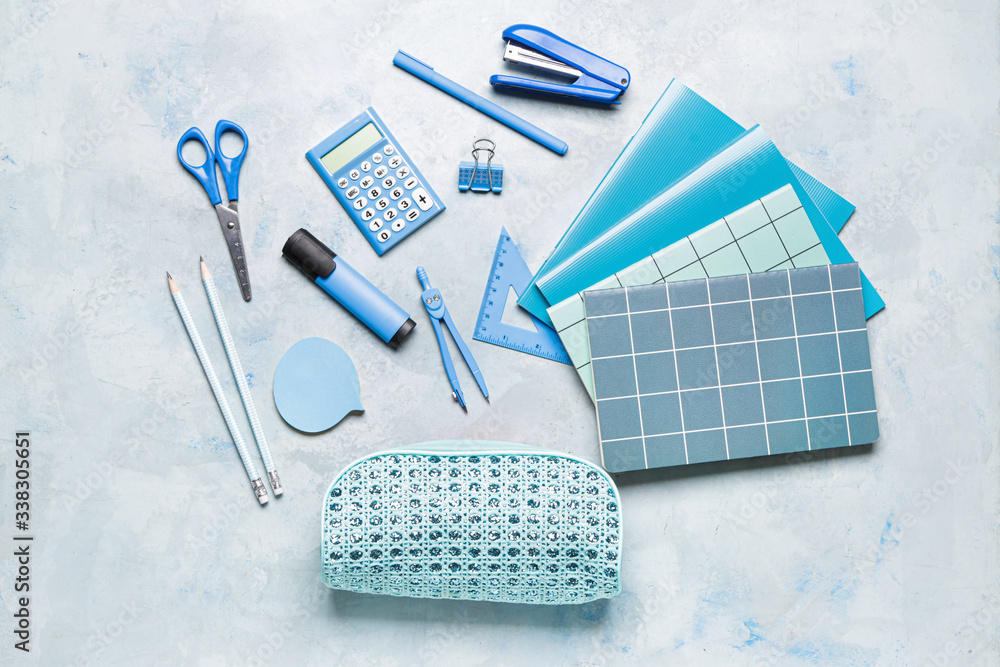 Pencil bag with stationery on color background