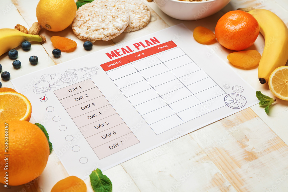Healthy products and meal plan on white wooden background