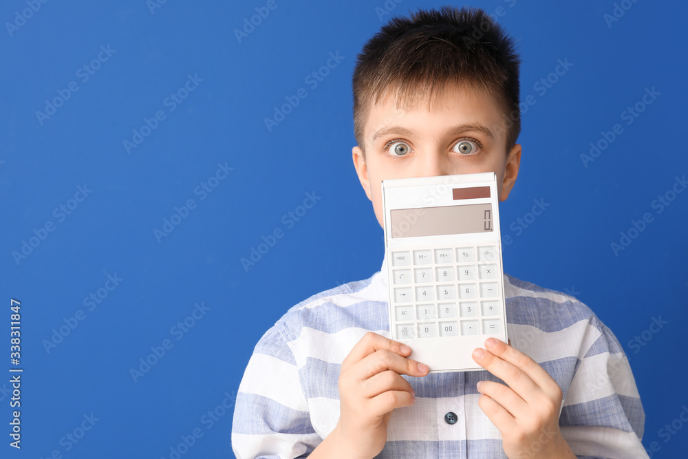 Surprised little boy with calculator on color background