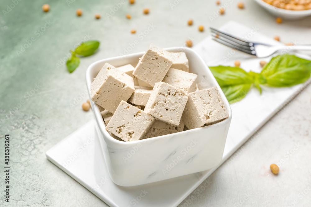 Bowl with tasty tofu cheese on table