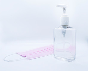 sanitizer jel bottle with pink face masks isolated on white background.