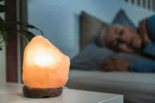 Mature Woman Sleeping With A Himalayan Salt Lamp In Bedroom