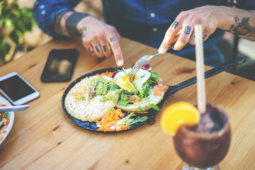 Wall Mural - Young man eating health food - Tattooed hand guy portrait having brunch in bar restaurant - Healthy nutrition lifestyle people