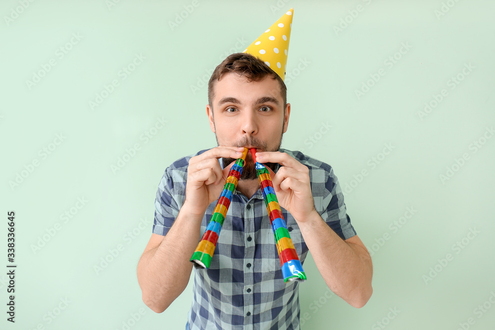 Handsome man celebrating Birthday on color background