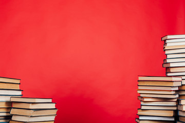 many stacks of educational books to study in the college library on a red background