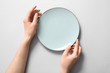 © Pixel-Shot - Woman at table with clean plate, top view