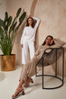 © indiraswork - Two beautiful sexy brunette woman friends face cosmetic makeup tanned skin wear fashion clothes style beige white knitted suit sandals accessory interior furniture armchair journey summer palm boho.