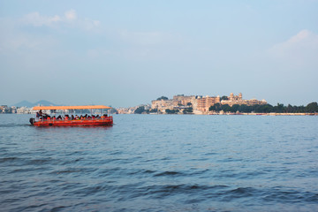 Fototapete - Toruist boat in Lake Pichola with City Palace in background. Udaipur, Rajasthan, India