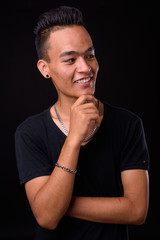 Portrait of happy young handsome Indian man thinking