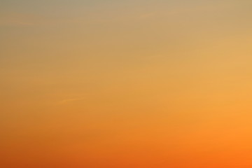 Sun below the horizon and fiery dramatic orange sky at sunset or dawn backlit by the sun. Place for text and design.