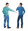 © ghoststone - Back view of two man in sweater pointing.