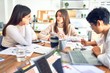 © Krakenimages.com - Beautiful businesswomen smiling happy. Sitting with smile on face working using smartphone and laptop at the office