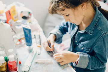 Wall Mural - portrait of young child girl crafting at home