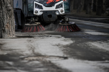 Wall Mural - Street cleaner vehicle on the road collecting garbage and junk with brush rotation and vacuum hoover