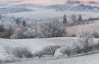 Winter Rural Landscape With With Frosted Wavy Plowed Fields, Trees In Hoarfrost And Old Windmill On The Hill. Beautiful Morning On The Wavy Arable  Fields Of Czech Republic. Rural Moravian Pastoral.
