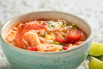 Wall Mural - Yummy Tom Yum soup on white stones with seashells