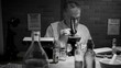In black and white a scientist during the 1918 influenza pandemic working in his private laboratory searching for a cure to the Spanish Flu.