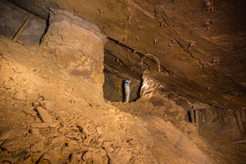 Miner explorer in abandoned bauxite ore mine tunnel board-and-pillar work cavity