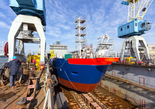 A Cargo Ship Is Building In A Dock At A Shipyard