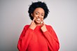 © Krakenimages.com - Young beautiful African American afro woman with curly hair wearing red casual sweater Smiling with open mouth, fingers pointing and forcing cheerful smile
